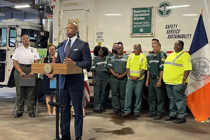 Mayor Eric Adams speaks at a city sanitation facility in Manhattan in June to announce the opening of the  department’s civil service exam to new applicants for the first time in seven years. The union representing sanitation employees has entered negotiations with the city for a new contract.